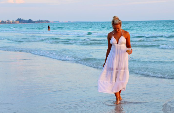 girl in dress walking on the beach