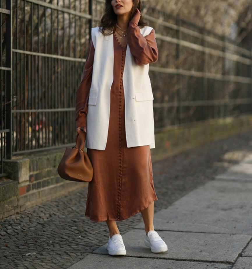Woman in midi dress and white sneakers