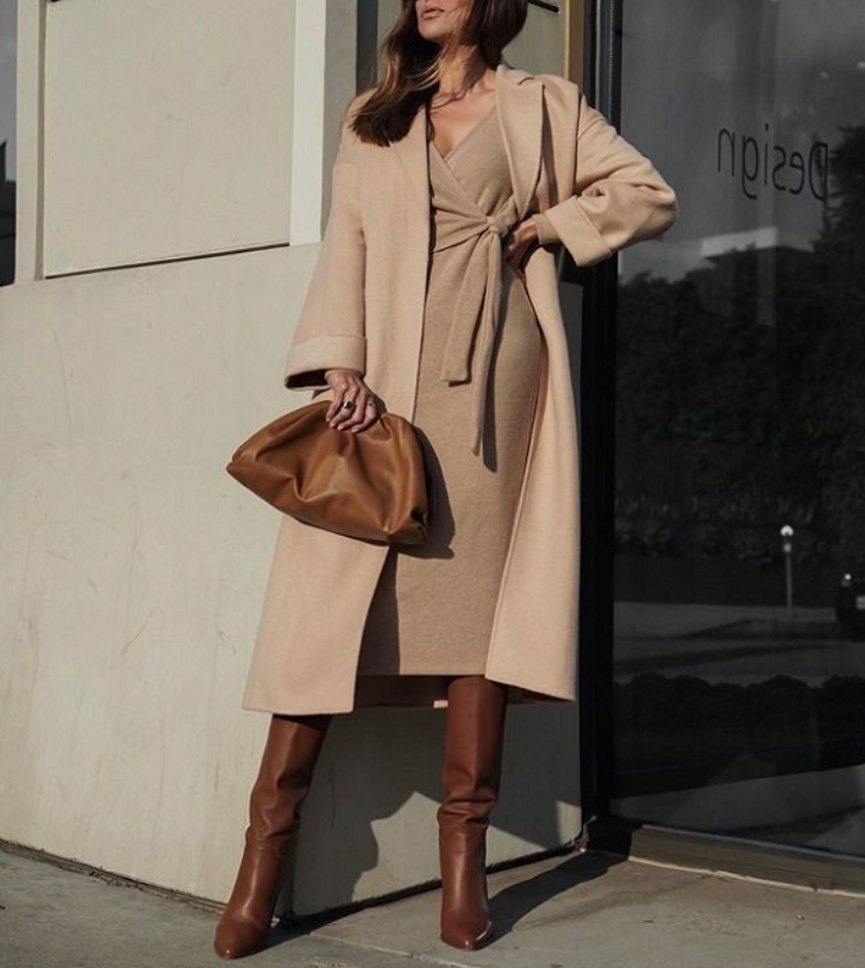 woman in beige midi dress with leather hand bag