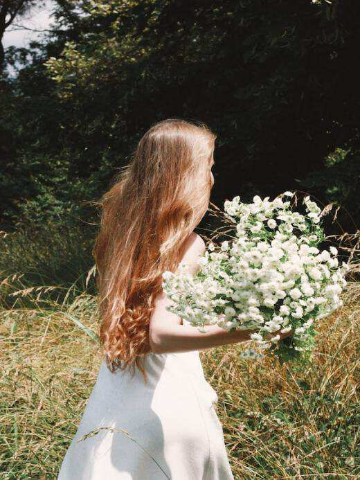 girl in white dress holding flowers